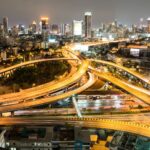 Elevated highway interchange and city skyline at night, illustrating Vile Parle East connectivity via the Western Express Highway and Mumbai Metro