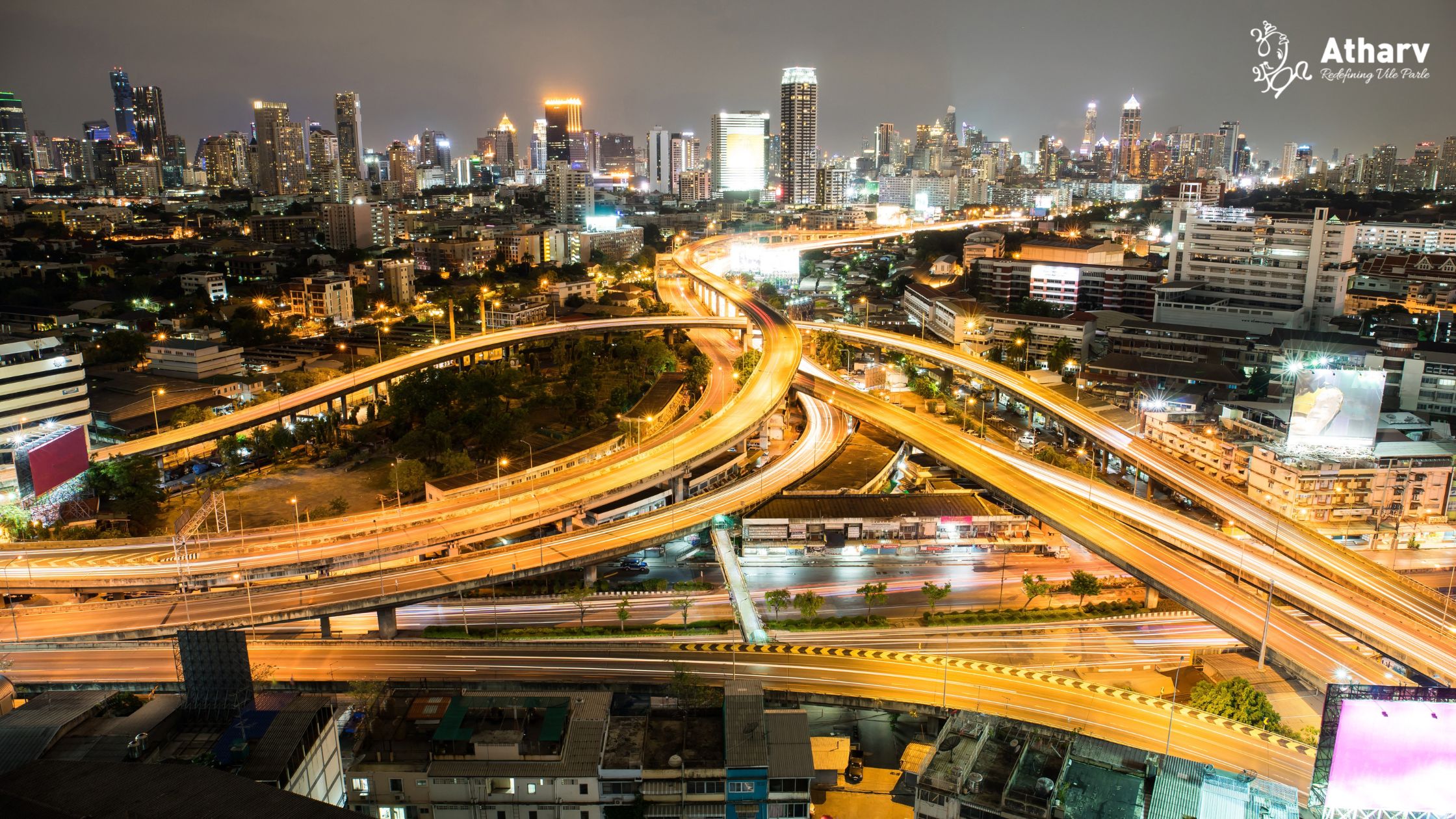 Elevated highway interchange and city skyline at night, illustrating Vile Parle East connectivity via the Western Express Highway and Mumbai Metro